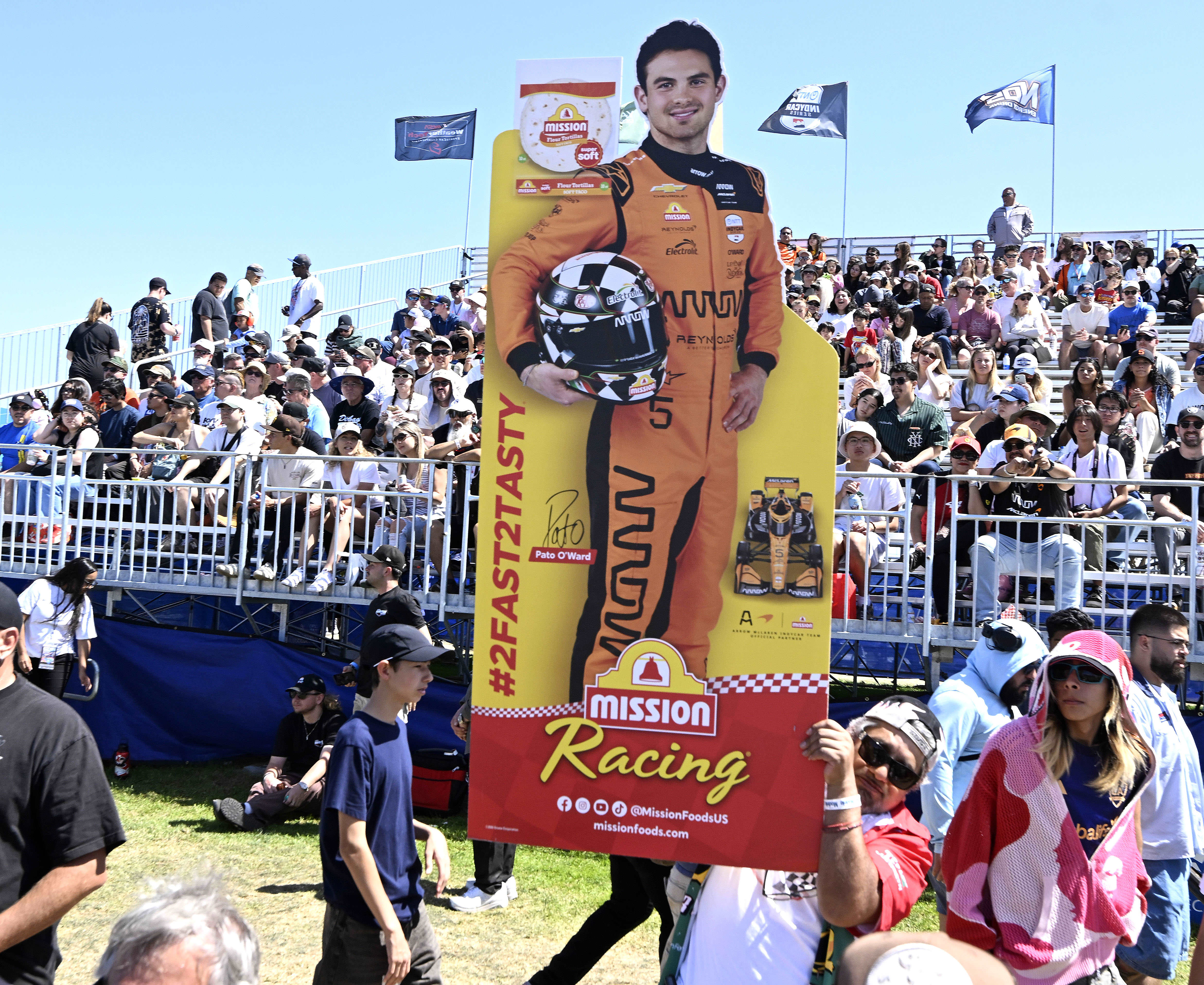A race fan carries a cardboard cutout of his favorite...