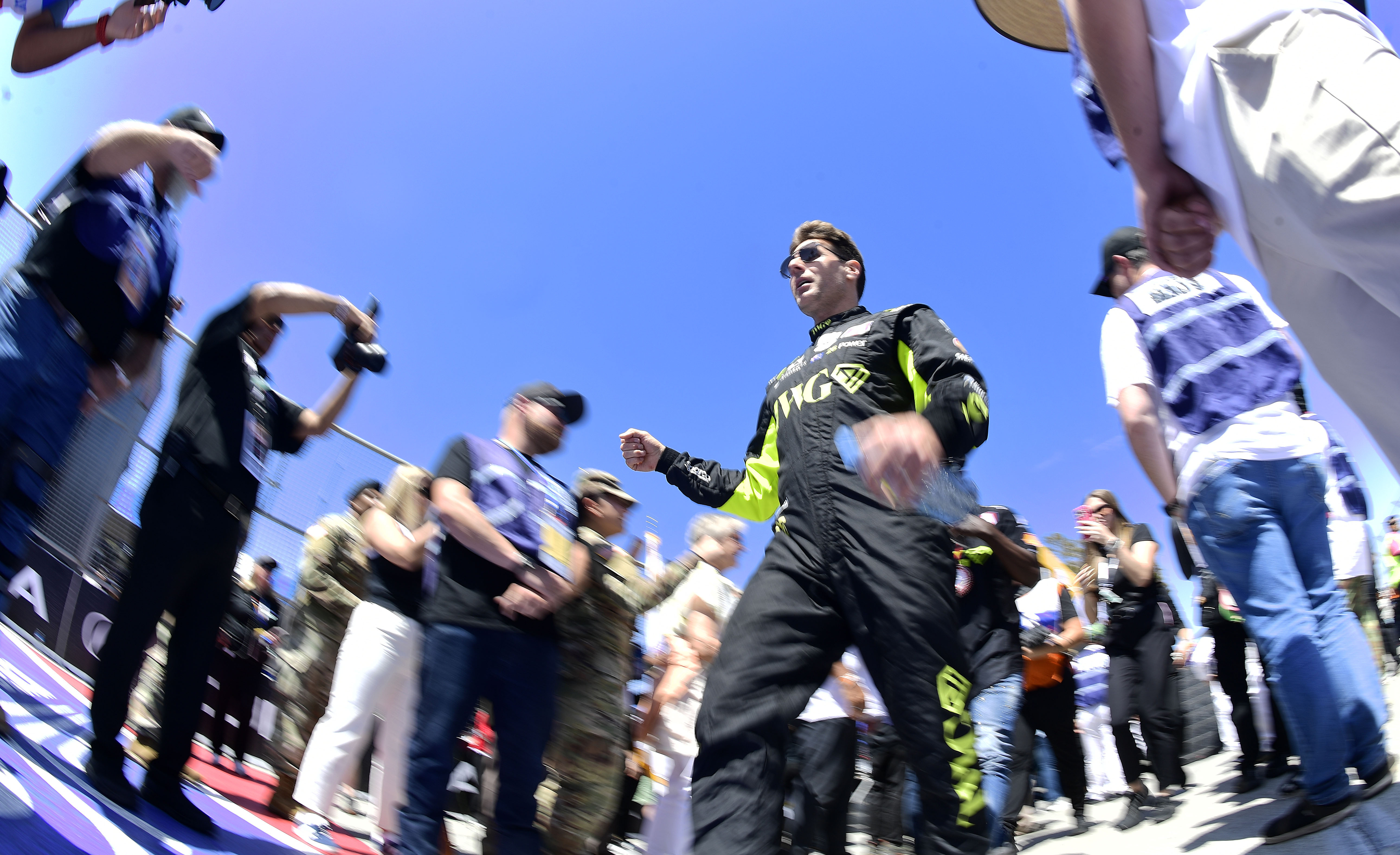 Indycar driver Will Power walks through a gauntlet of fans,...