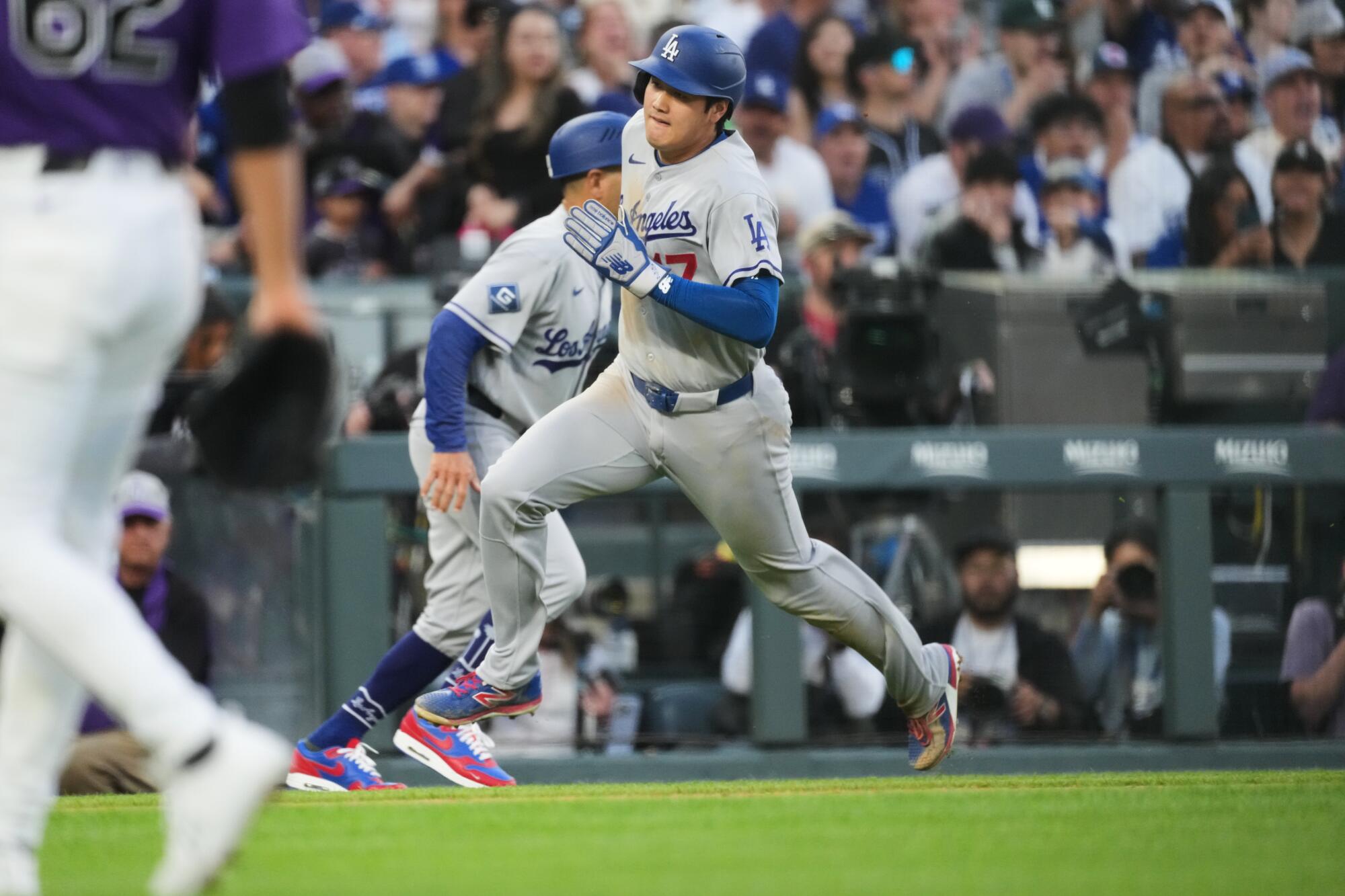 Dodgers star Shohei Ohtani rounds third base on his way to scoring against Colorado.