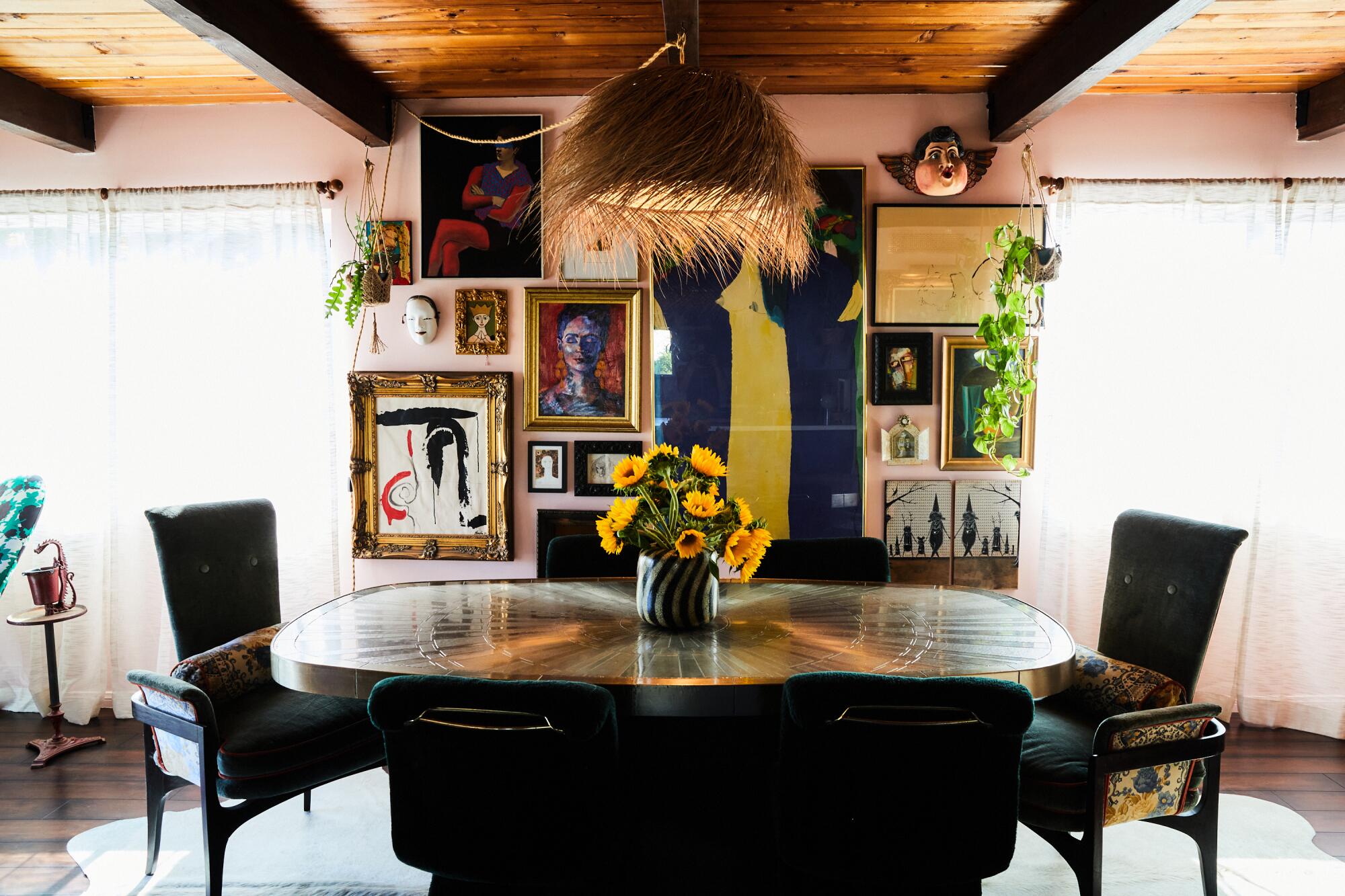 A dining room with art hung salon style on the wall.