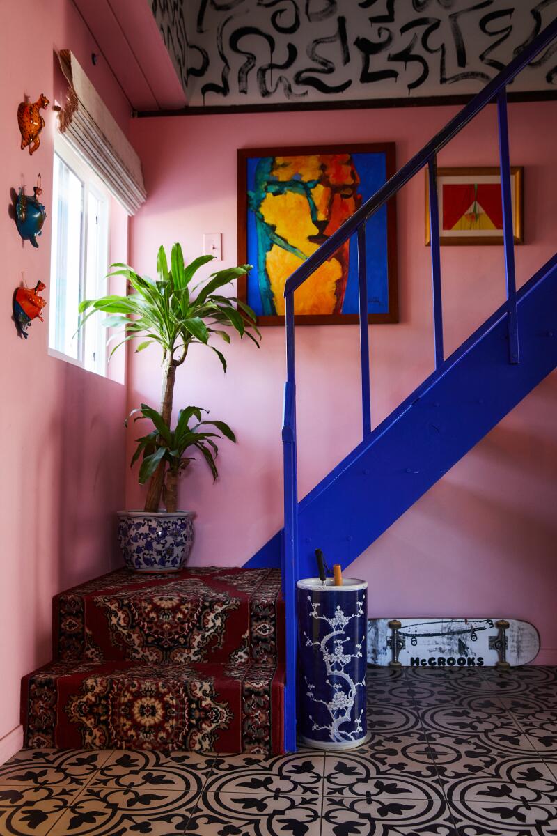 A staircase leading up to the second level, backed by a pink wall.