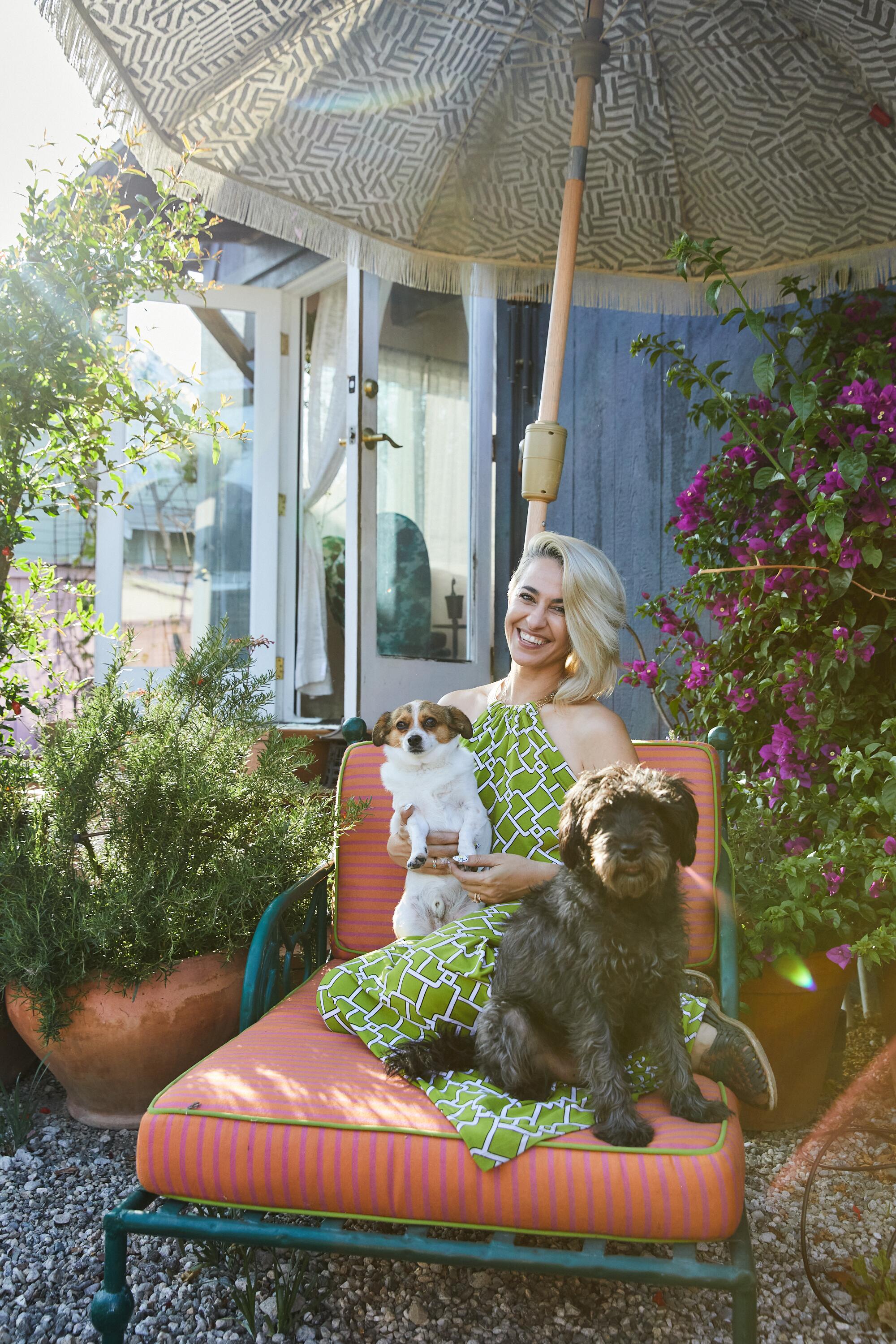 Designer Meeshie Fahmy pictured with her pet dogs in her garden.