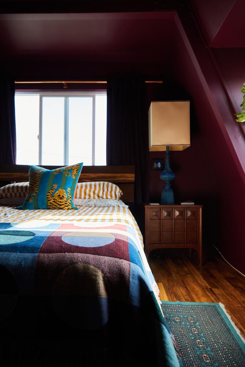 A bedroom with burgandy walls 