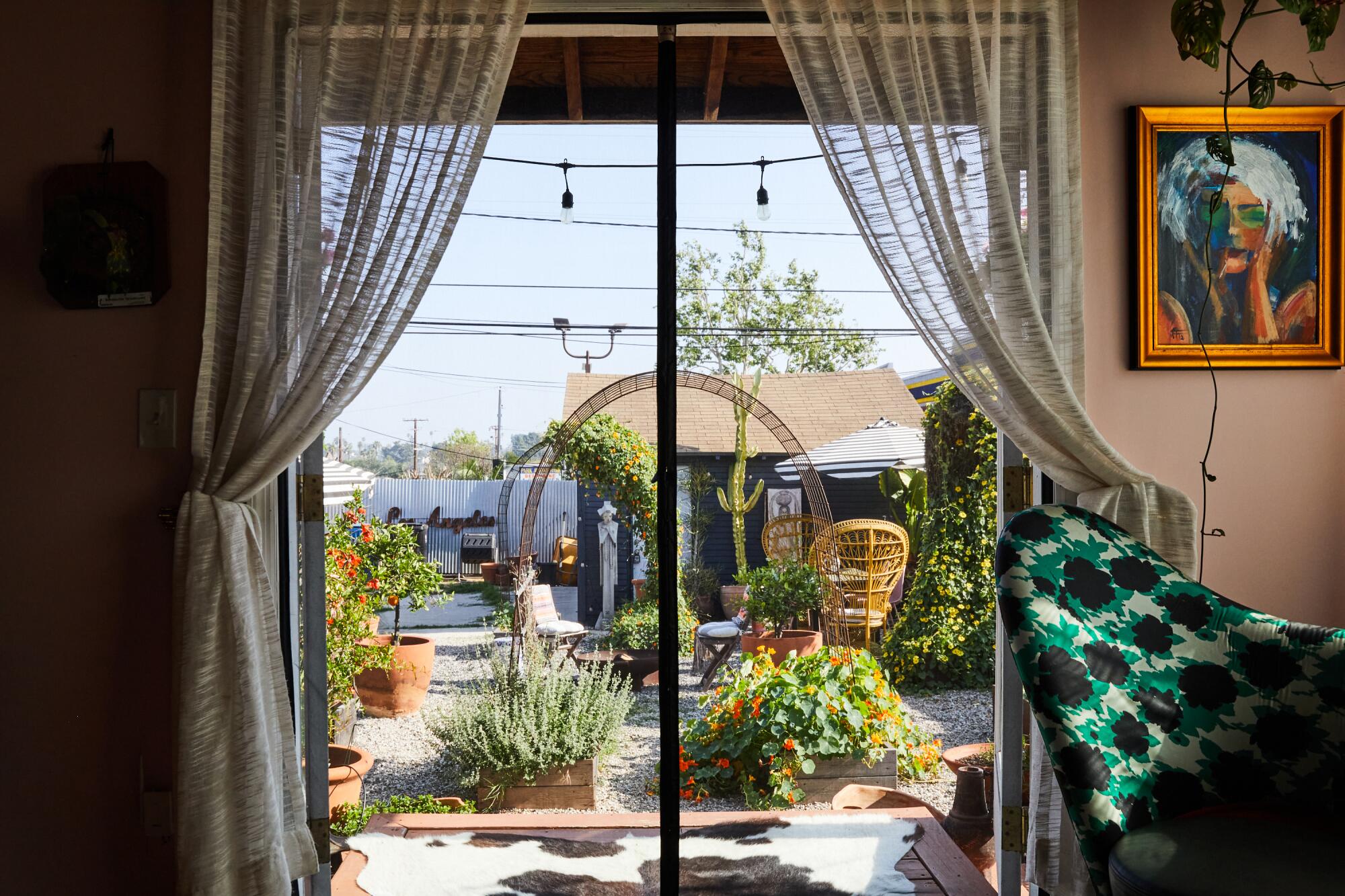 View of designer Meeshie Fahmy and Aaron Snyder's dining room looking onto their outdoor garden in their home.