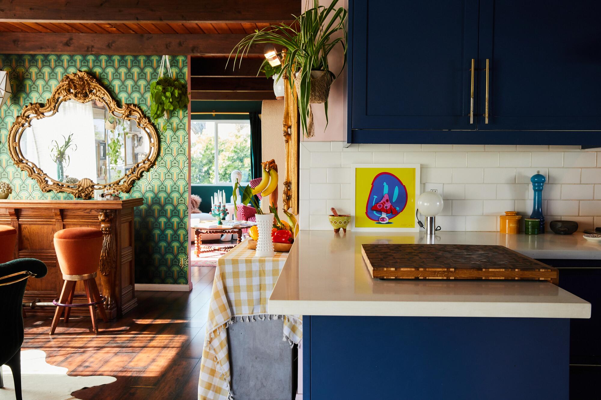 A blue kitchen looking into the living room.