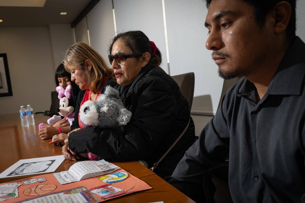 Four people sit at a conference table.