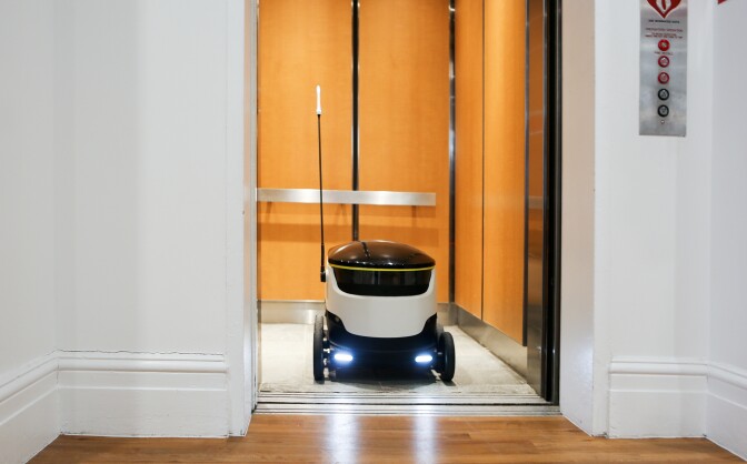 Starship Technologies' delivery robot exits the elevator in the company's office.