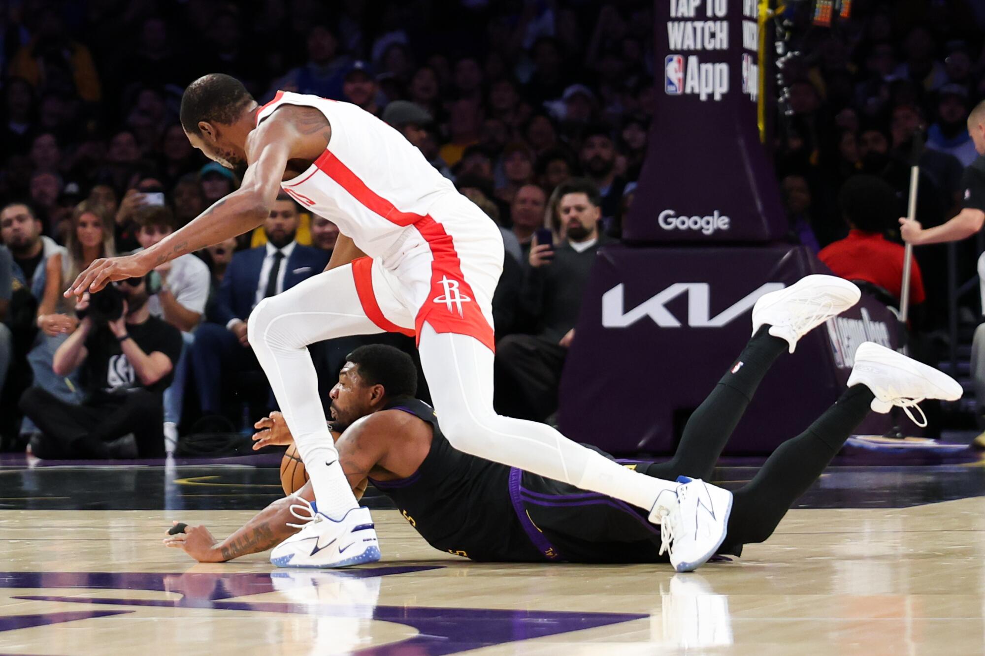Lakers guard Marcus Smart, sprawled on the court, steals the ball from Rockets forward Kevin Durant during the first quarter.
