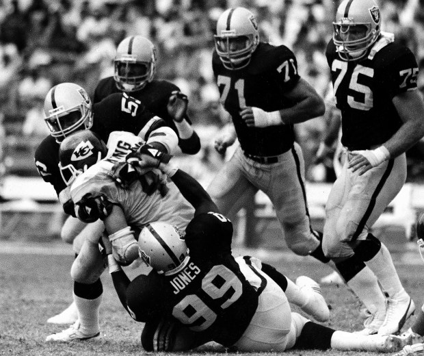 Kansas City Chiefs running back Bruce King is pulled down for no gain by Los Angeles Raiders Rod Martin (53) and Sean Jones (99) during second quarter of NFL game at the Coliseum in Los Angeles, Oct. 7, 1988. Other Raiders moving in are Mike Davis, Bill Pickel and Howie Long, back, left to right. (AP Photo/Lennox McLendon)