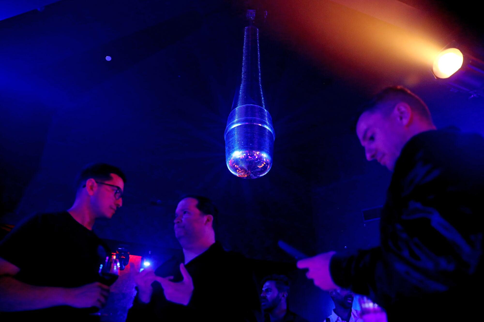 A disco-themed mirrored microphone hangs from the ceiling.