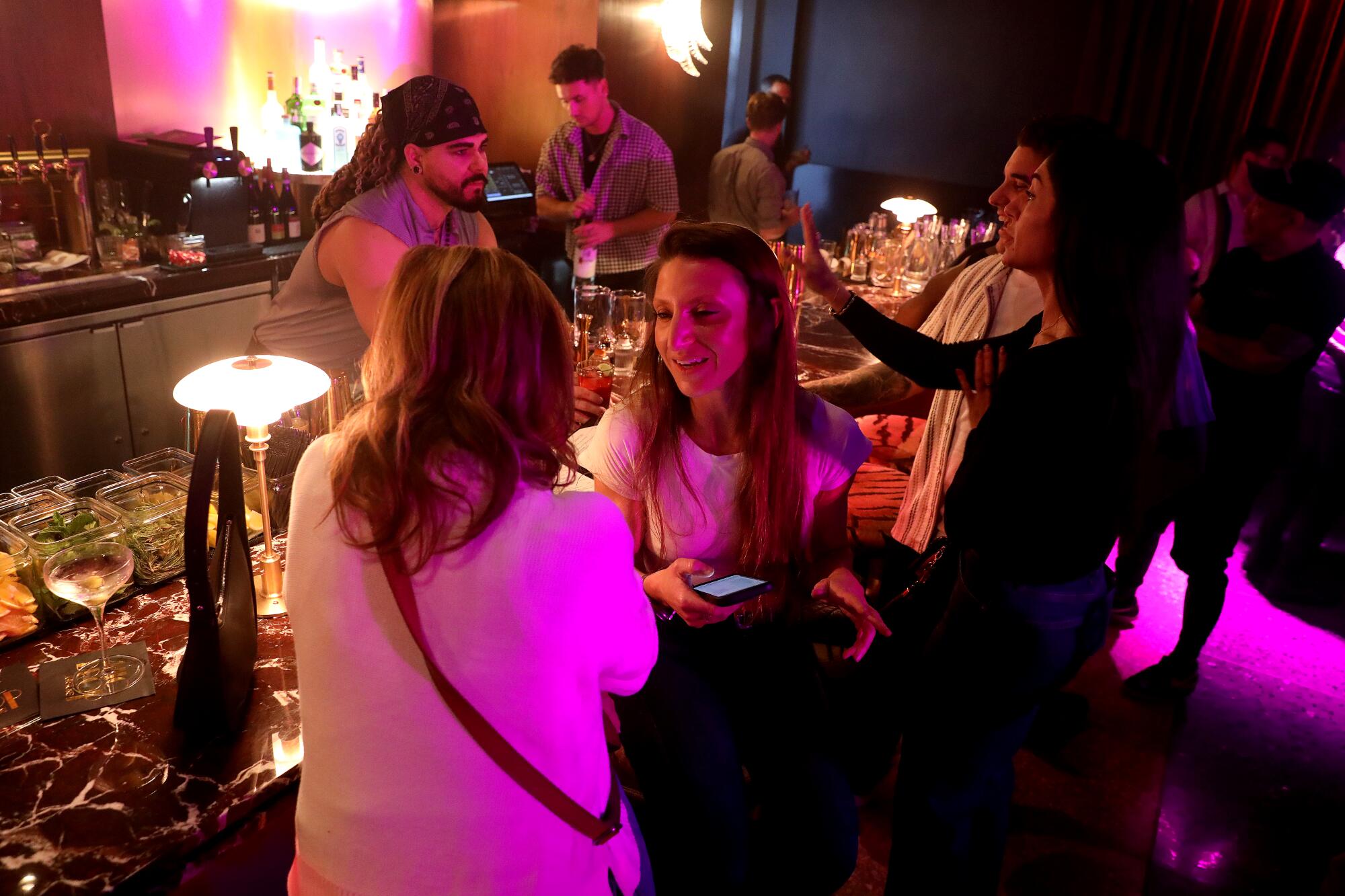 Sarah Rothman, center, of Oakland, and friend Rachel Bernstein, left, of Los Angeles, wait at the bar.