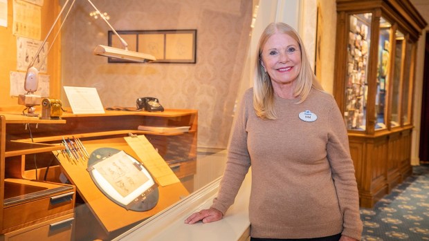 Disney Legend Kim Irvine with the Disney100 exhibit in the Disney Gallery at Disneyland. (Courtesy of Disneyland)