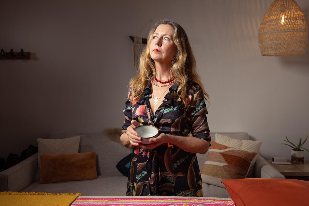 A radical well womb and pelvic care practitioner holds a bowl of coconut and castor oil that she uses often with her clients 