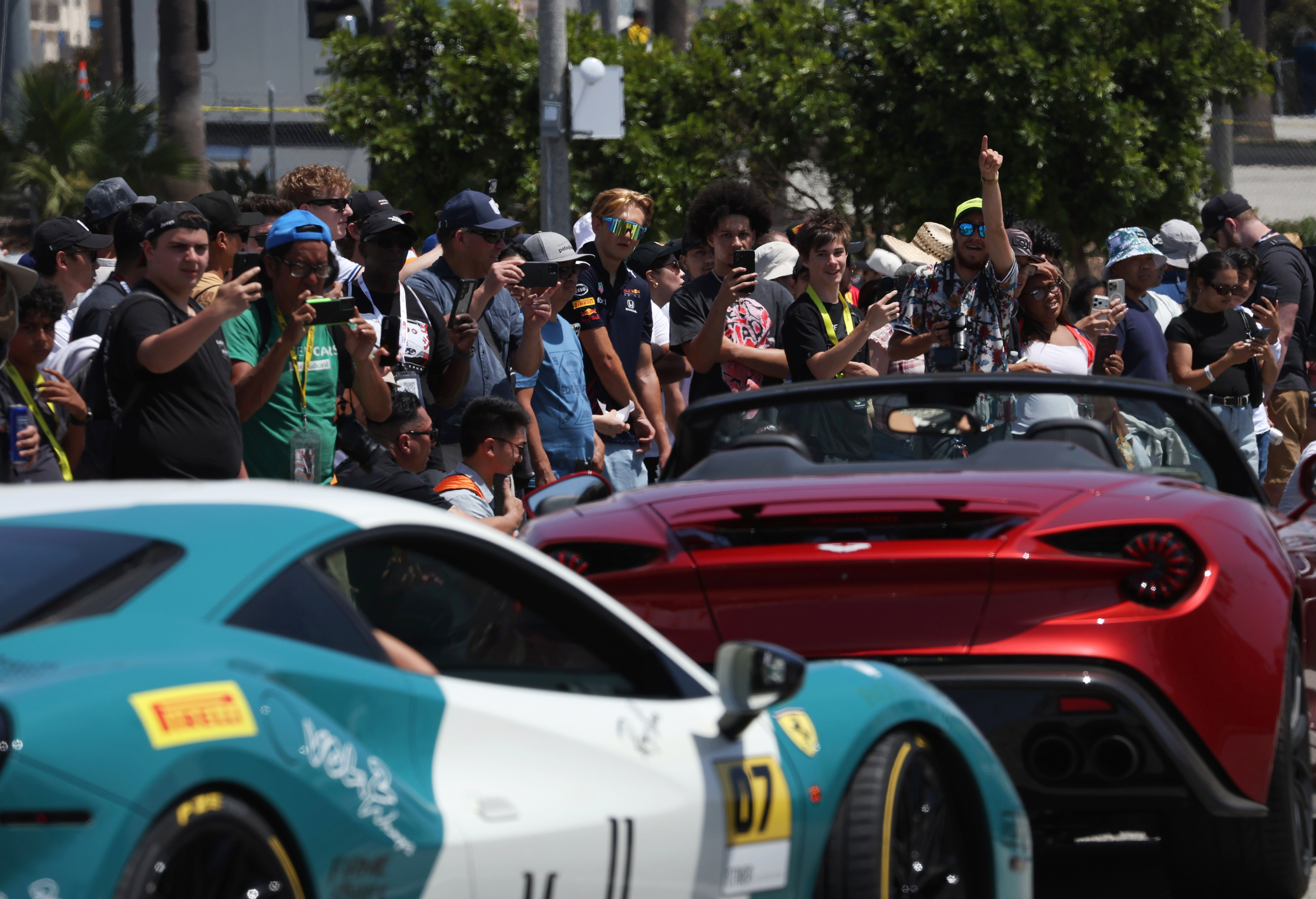 Motorsport fans watch as sports cars roll past during the...