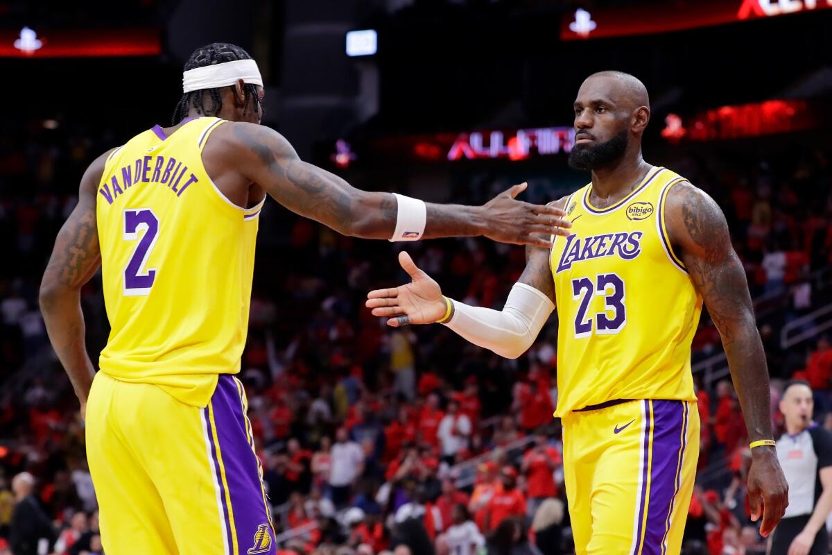 Lakers forwards Jarred Vanderbilt, left, and LeBron James celebrate after their overtime against the Houston Rockets.