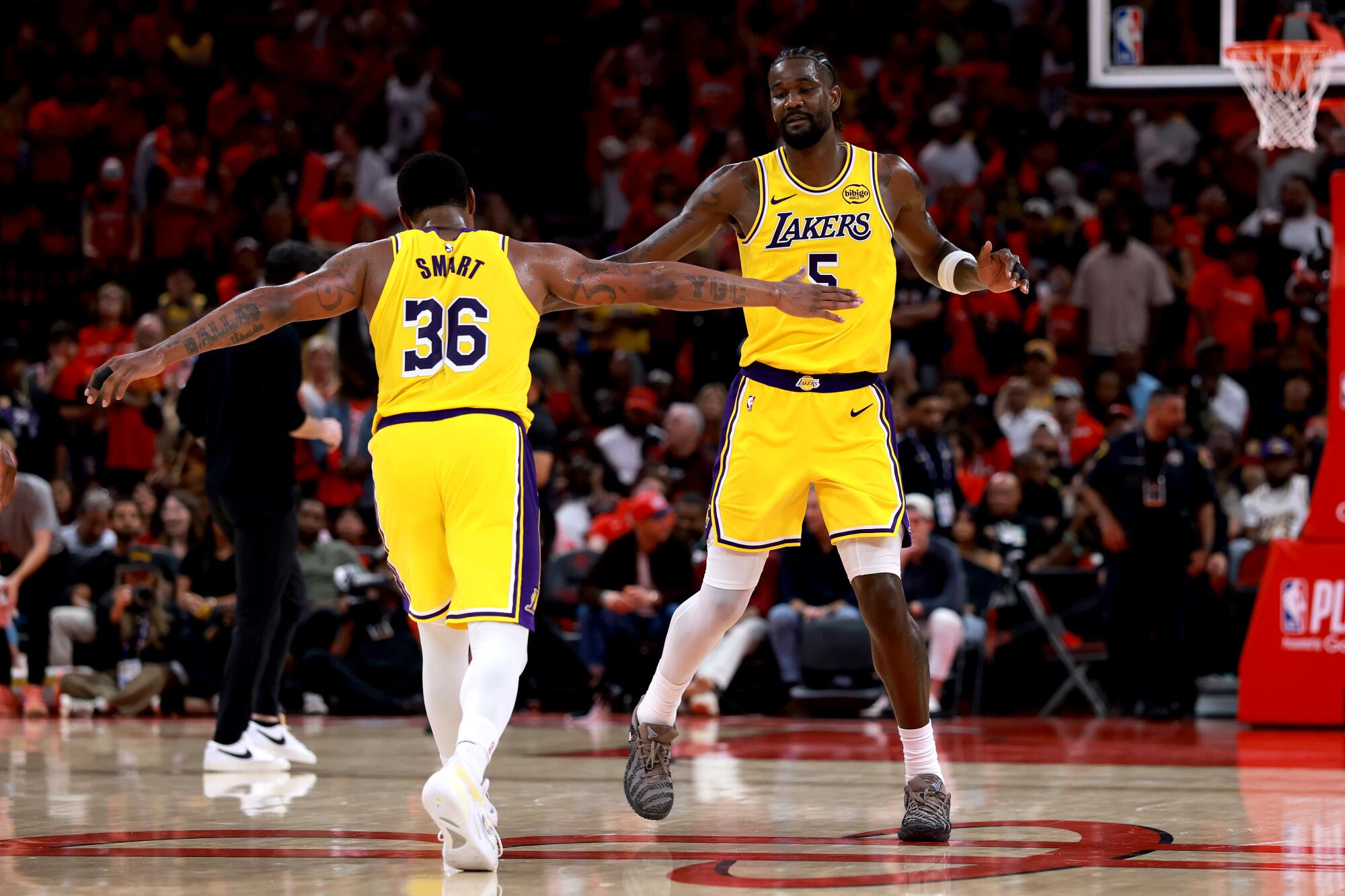 Lakers center Deandre Ayton, right, and guard Marcus Smart slap hands as they celebrate in overtime during their win Friday.