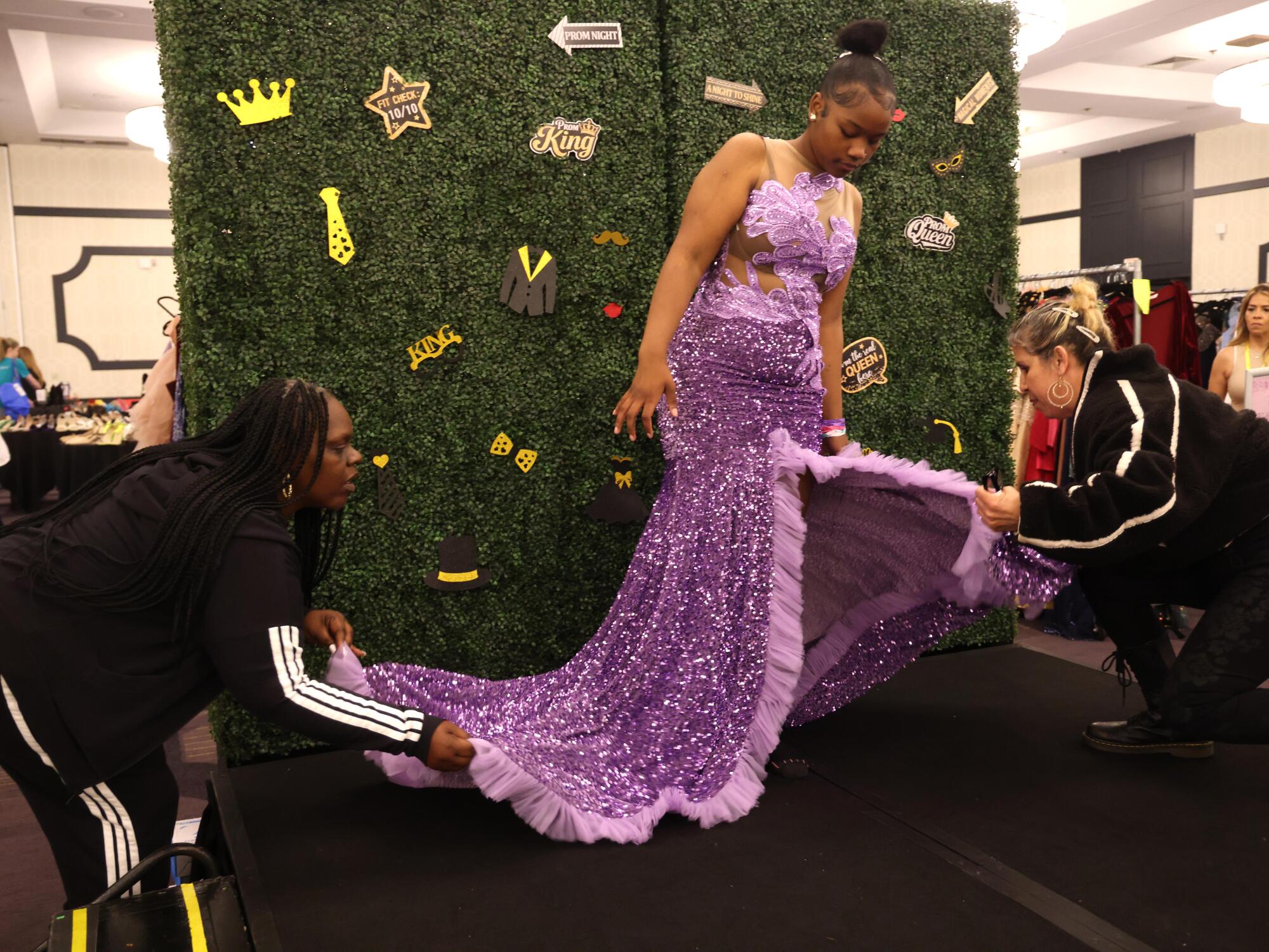 Volunteers Tanya Jackson and Norma Yanez help Saphiera Stillwell with her prom dress.