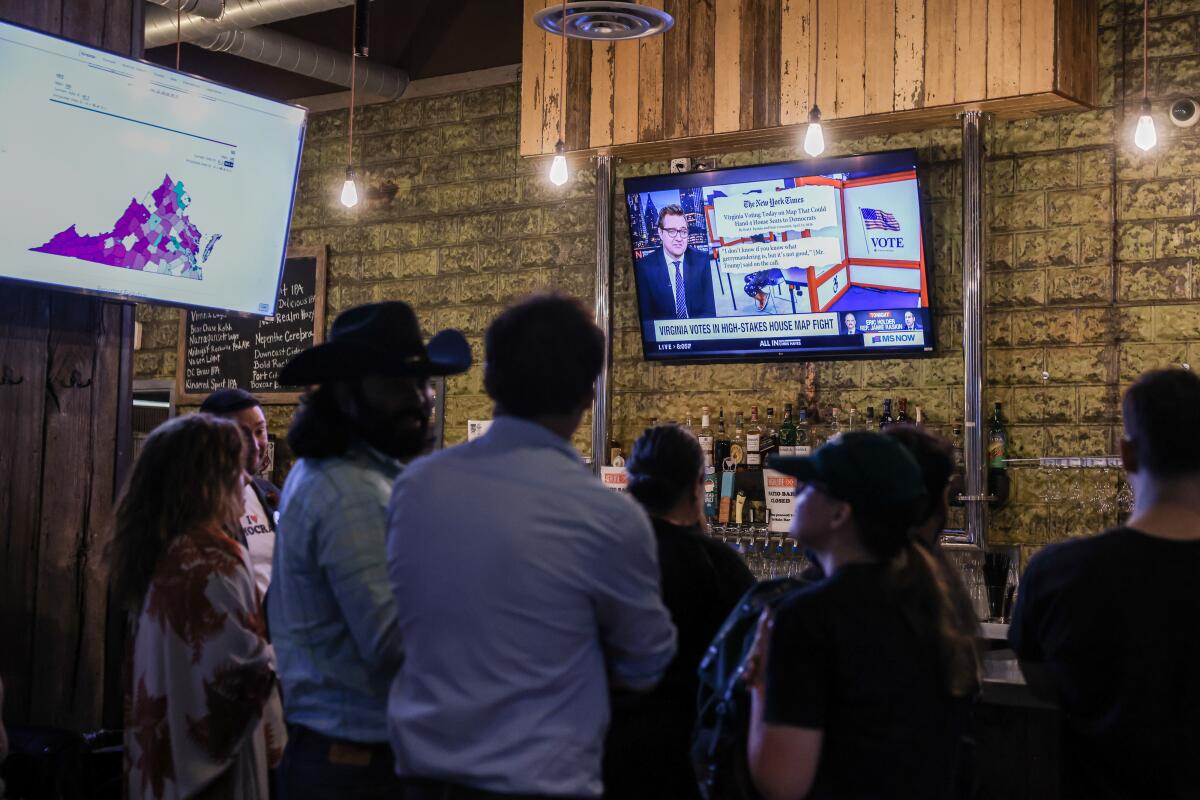 A gathering of Virginia voters in front of television screens