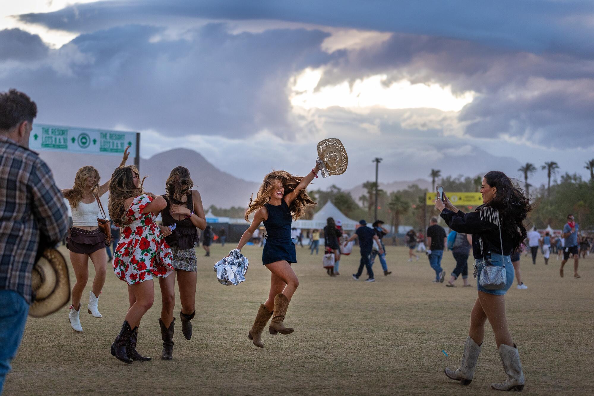 A woman holds a hat in the winds at Stagecoach