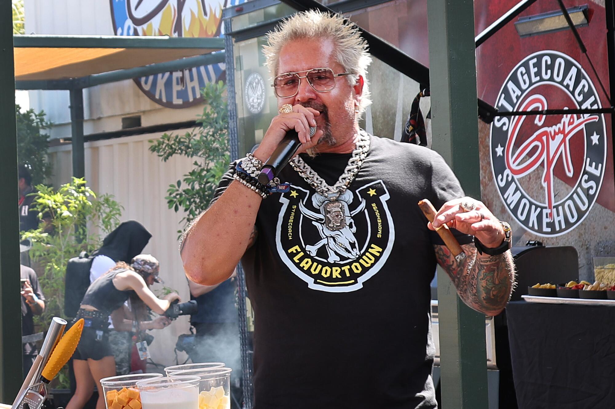 Guy Fieri holds a microphone at Stagecoach