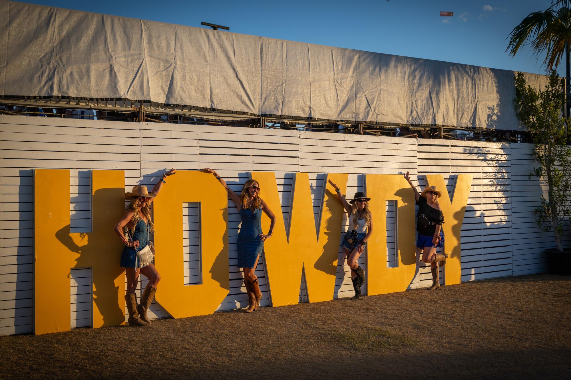 four women pose in front of a sign that says "Howdy" at Stagecoach