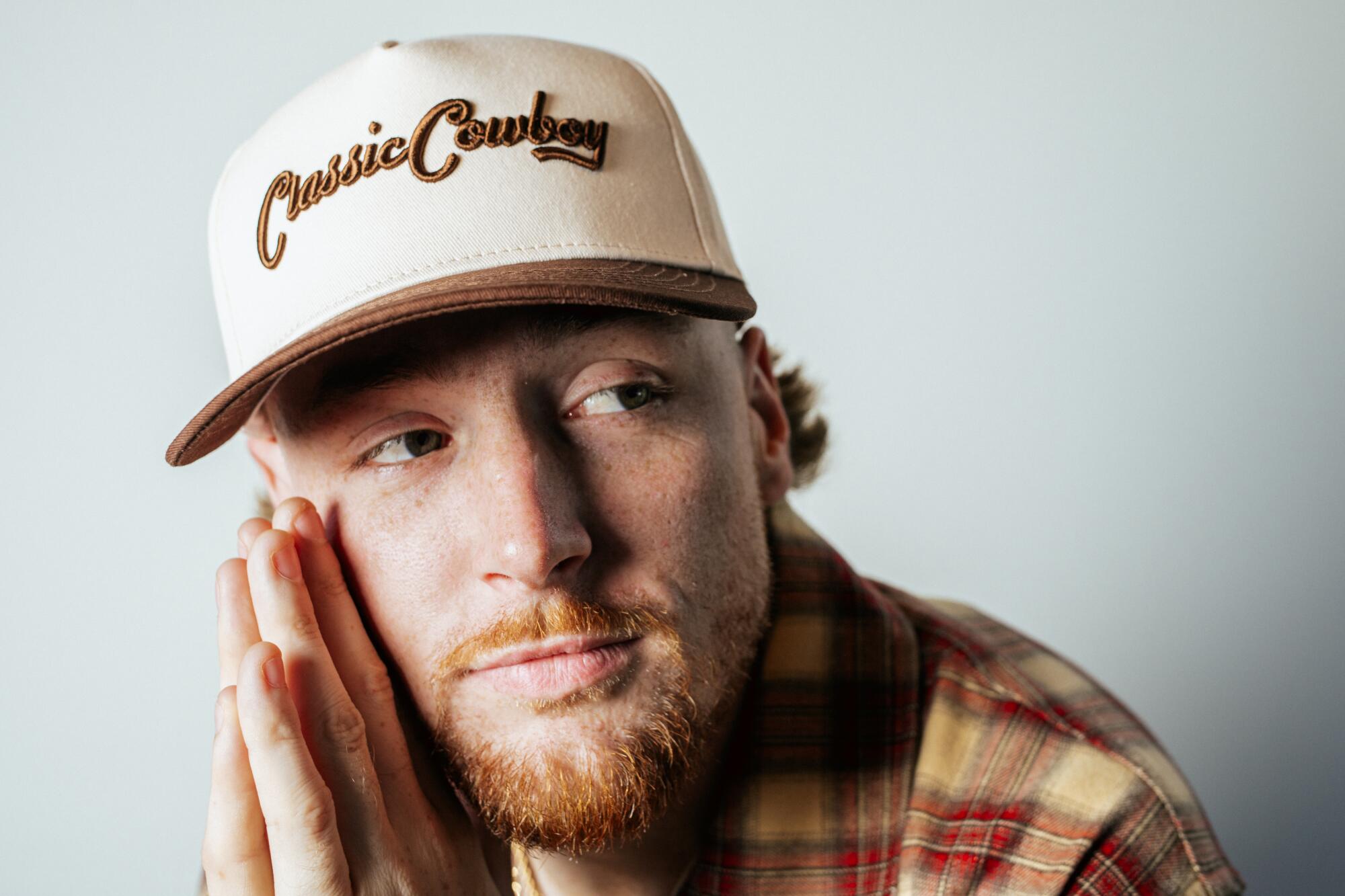 Man in white baseball cap making prayer hands