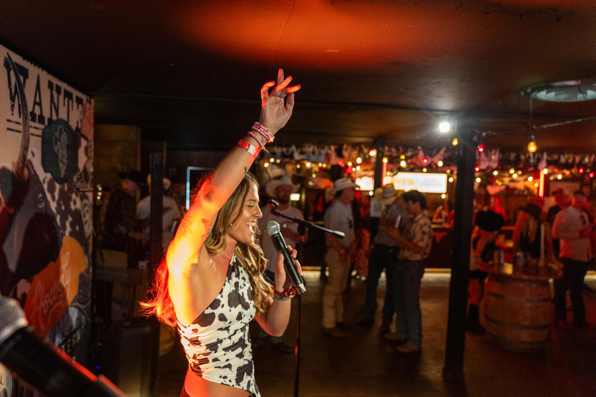 A woman sings karaoke inside a pop-up bar at Stagecoach