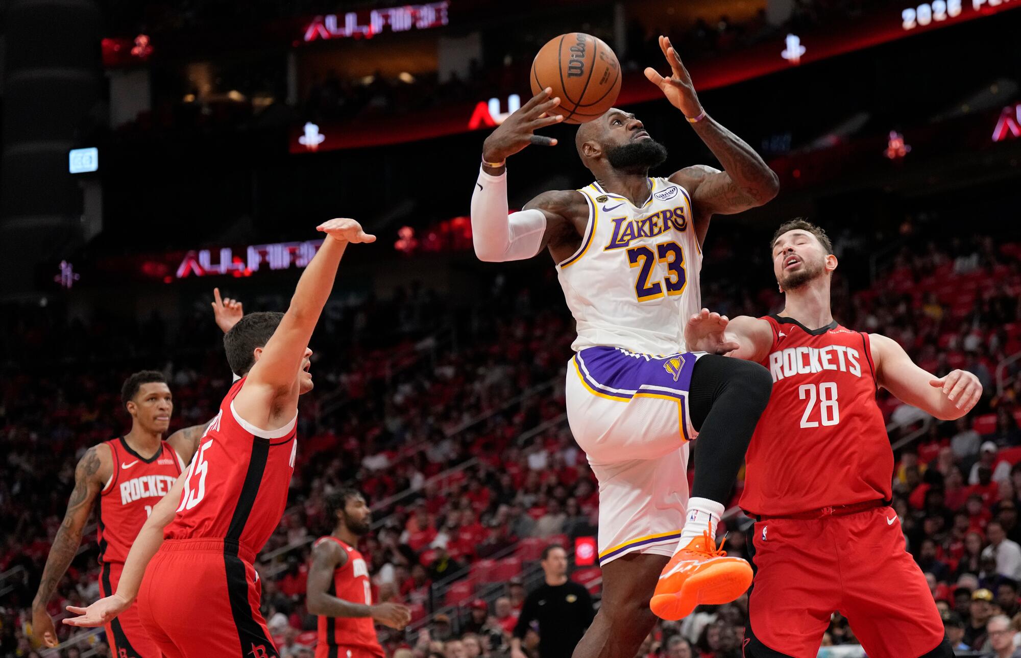 Lakers star LeBron James drives to the basket over Houston's Reed Sheppard, left, and Alperen Sengun.