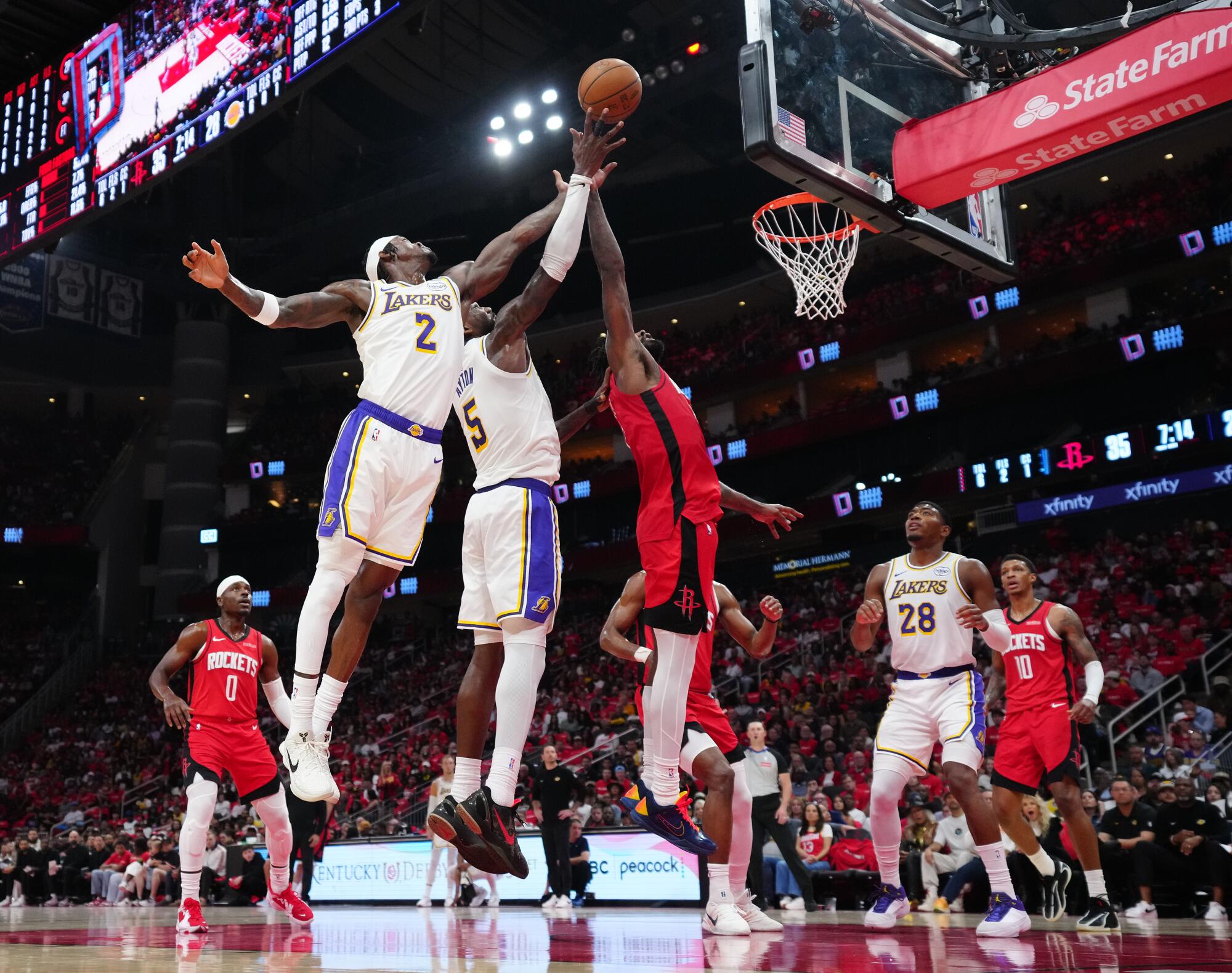 Lakers' Jarred Vanderbilt (2) and Deandre Ayton (5) go up for a rebound against Houston forward Tari Eason.