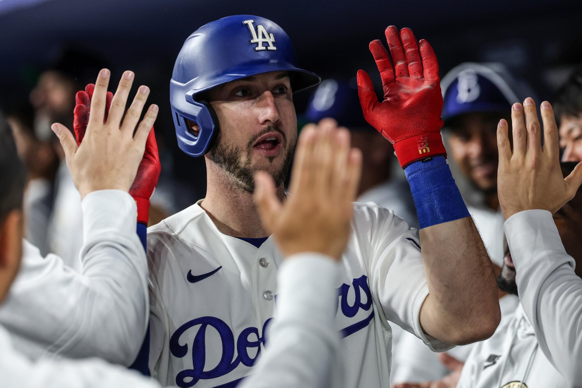 Dodgers right fielder Kyle Tucker celebrates with teammates in the dugout after hitting a home run.