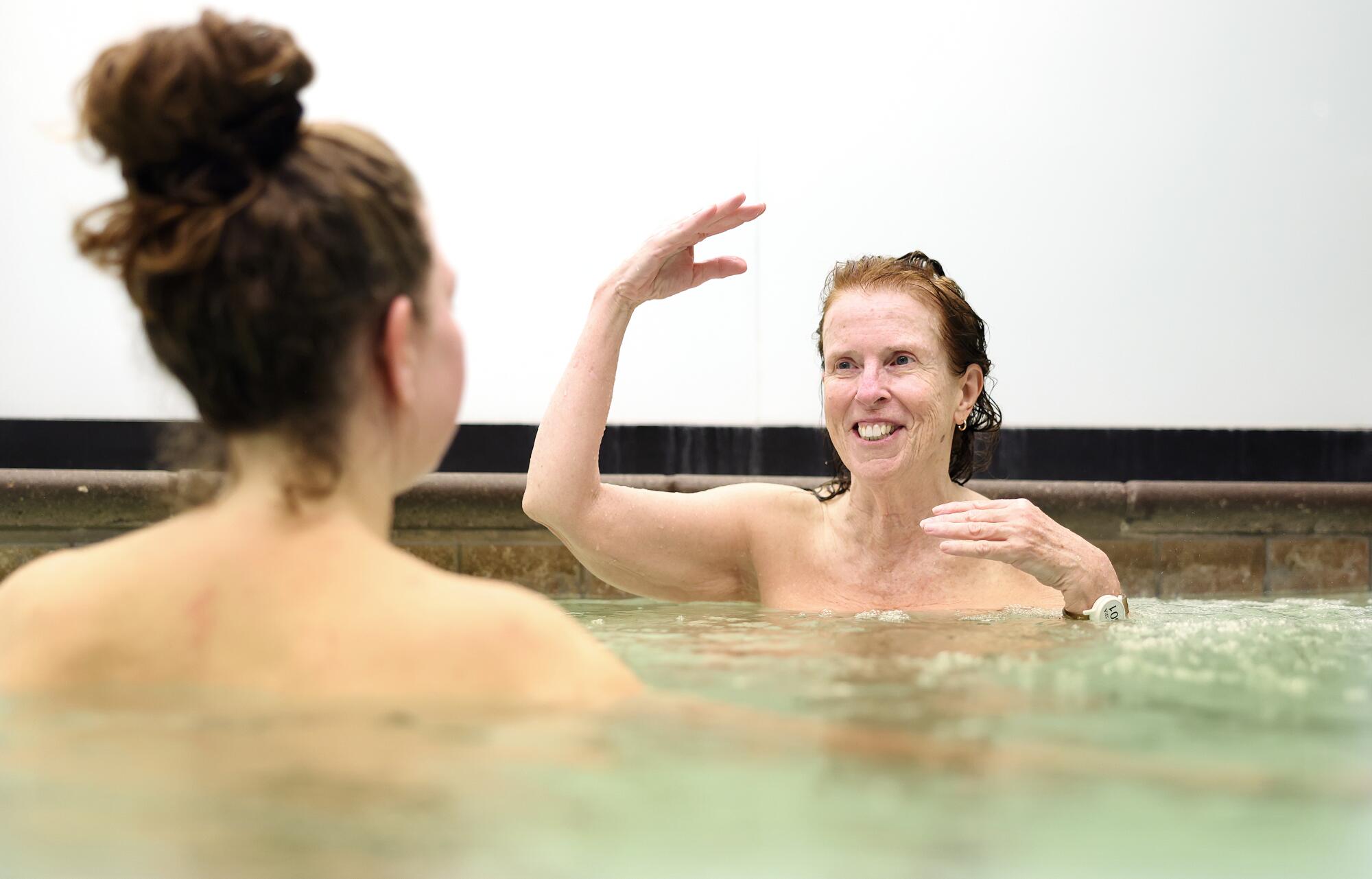 Two women chat in a hot tub.