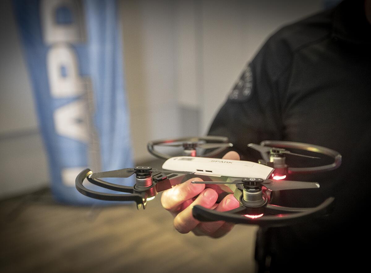 A hand holds a small drone.