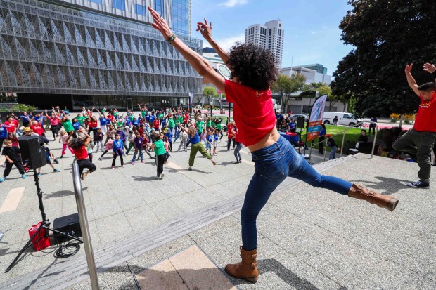 One Dance instructors Amy Rose, left, and artistic director Dudley Flores, right, lead a high-energy dance during the Bay Area Dance Week kickoff eventin San Francisco, Friday, April 24, 2026. Bay Area Dance Week is a 10-day celebration of various dance styles held throughout the Bay Area. The One Dance performance included a Soul Line Dance class led by Oakland's Chocolate Platinum. (Ray Chavez/Bay Area News Group)