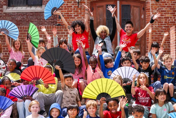 Rooftop Elementary School third graders gather for a group photo with One Dance instructors Amy Rose, top left, and artistic director Dudley Flores, right, and Soul Line Dance instructor Chocolate Platinum of Oakland, top middle, after dancing during the Bay Area Dance Week kickoff event at Jesse Square in San Francisco, Friday, April 24, 2026. Bay Area Dance Week is a 10-day celebration of various dance styles held throughout the Bay Area. The One Dance performance included a 30-minute Soul Line Dance class led by Platinum. (Ray Chavez/Bay Area News Group)