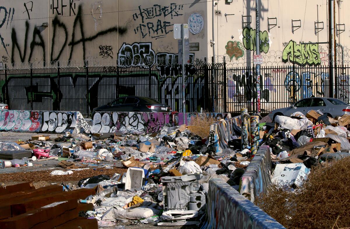 Trash and graffiti all over a street.