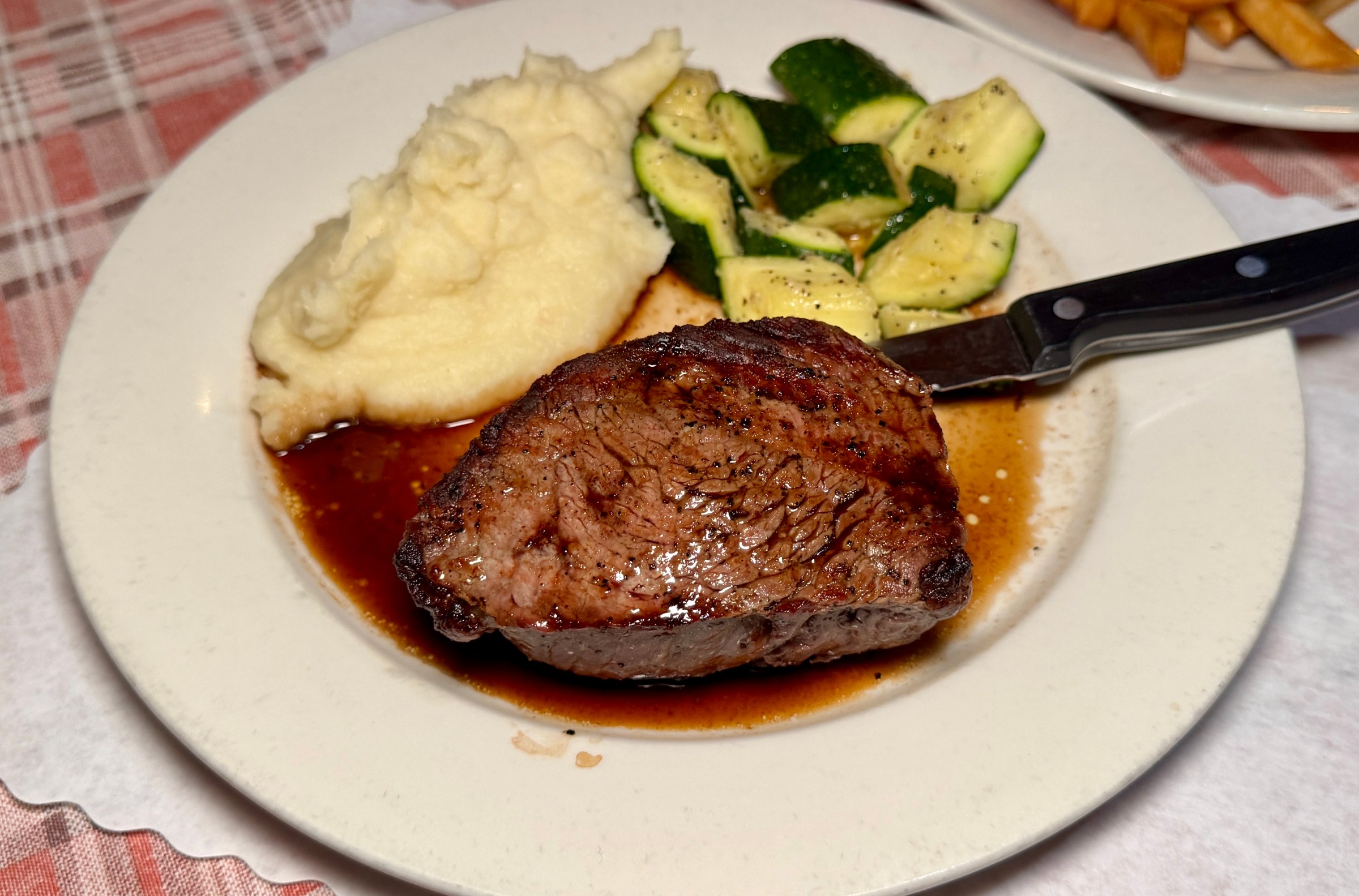 Baseball steak with mashed potatoes and zucchini at HMS Bounty