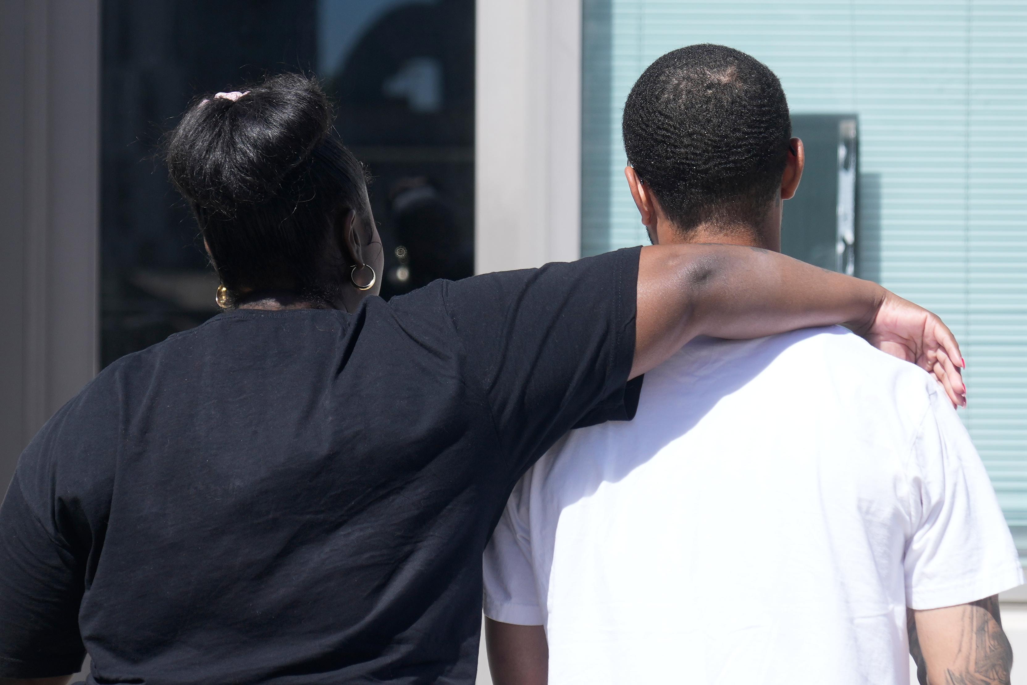 Oakland Ceasefire-Lifeline life coach LaSasha Long, left, puts her arm...