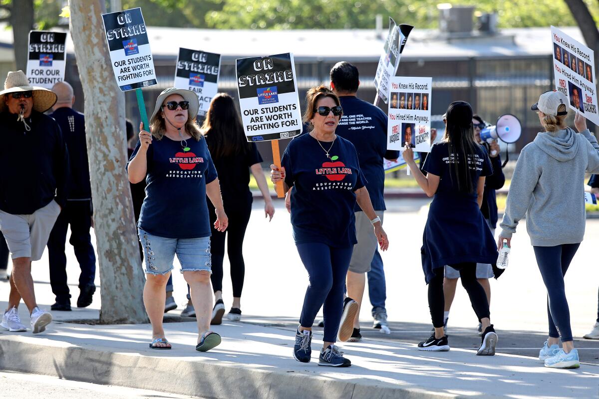 Striking teachers picket in front of a school.