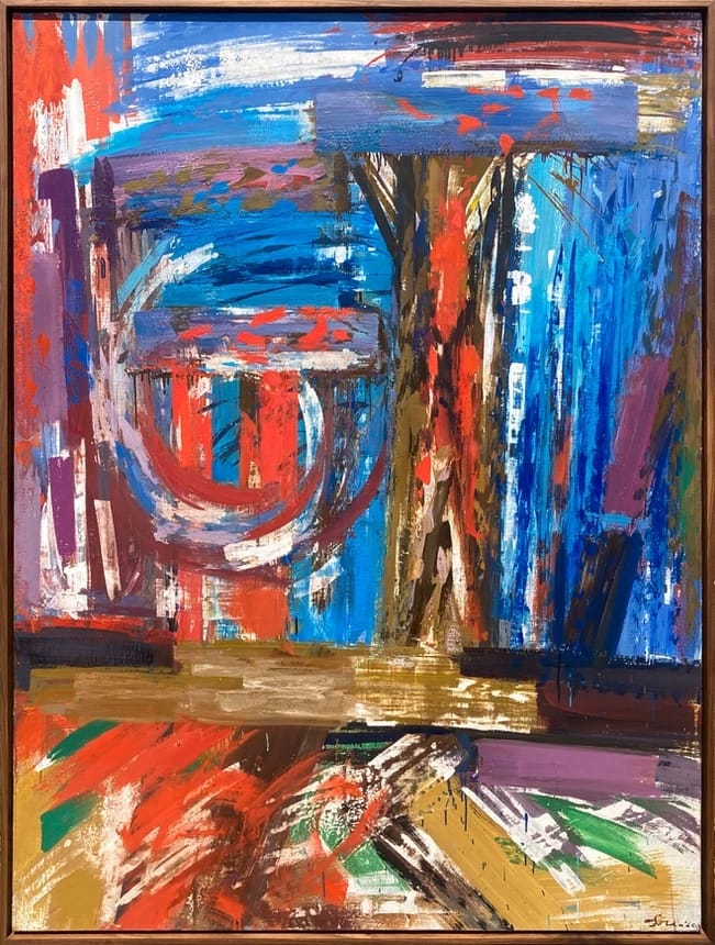 An abstract painting filled with bold, expressive brushstrokes in vibrant blues, reds, whites, and earthy tones. The composition features layered shapes and gestural marks, including vertical and horizontal forms and a circular motif on the left, creating a dynamic, energetic scene within a wooden frame. Featured at San Francisco Art Fair 2026.
