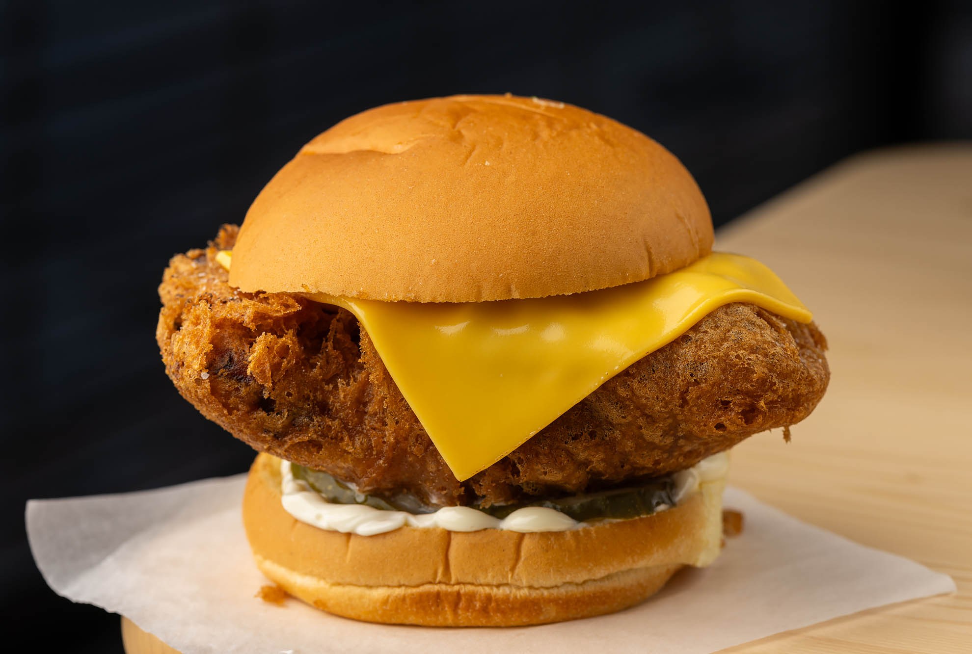 Fried fish sandwich with beer-battered Pacific striped bass, American cheese, Kewpie mayo, dill pickles, and potato bun at Little Fish.
