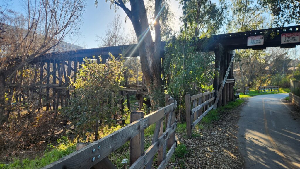 A train trestles running over a winding road.