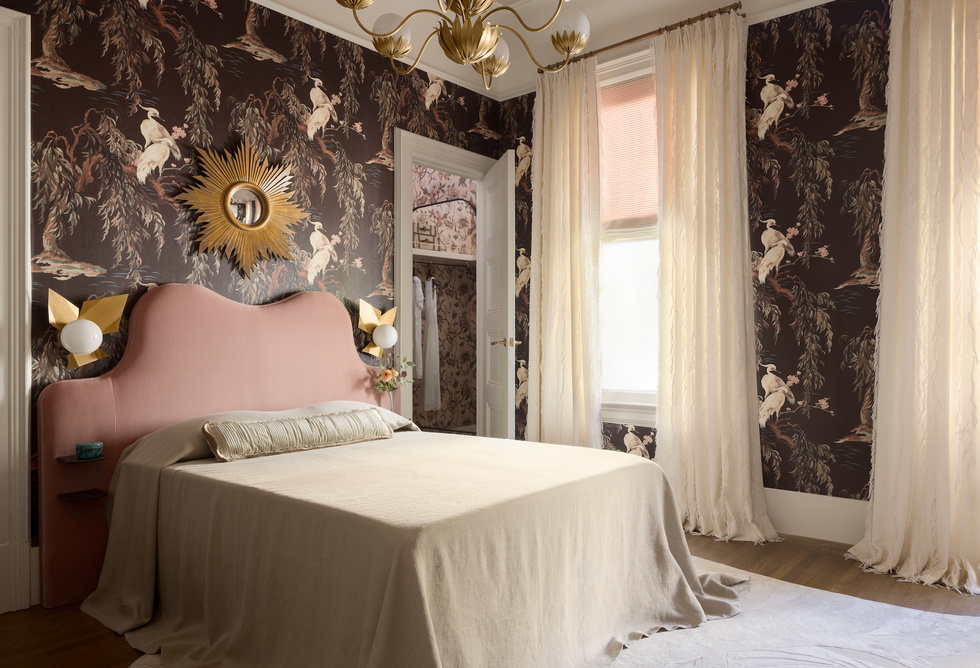 Modern bedroom with a pink upholstered bed and patterned wallpaper. Modern bedroom with a pink upholstered bed and patterned wallpaper.