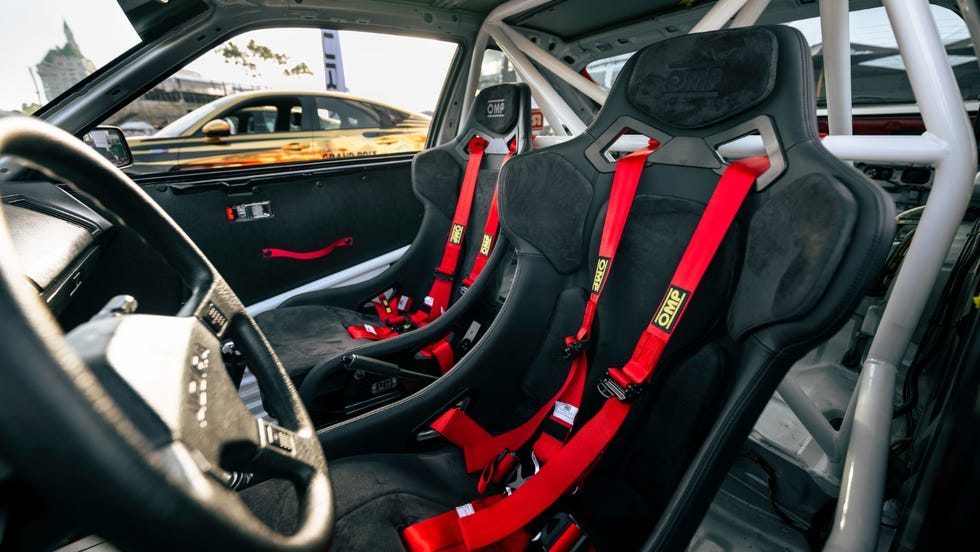 interior view of a race car featuring bucket seats and safety harnesses