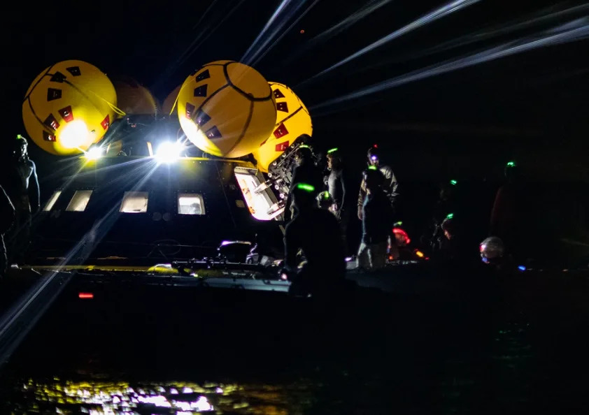 U.S. Navy Sailors assigned to Explosive Ordnance Disposal Mobile Unit 1 and Helicopter Sea Combat Squadron 23 “Wildcards” assist astronauts out of a crew module test article (CMTA) onto a life raft while underway with San Antonio class amphibious ship USS San Diego (LPD 22) for NASA’s Underway Recovery Test 11, Feb. 27, 2024. In preparation for NASA’s Artemis II crewed mission, which will send four astronauts in Orion beyond the Moon, NASA and the Department of Defense will conduct a series of tests to demonstrate and evaluate the processes, procedures, and hardware used in recovery operations for crewed lunar missions. The U.S. Navy has may unique capabilities that make it an ideal partner to support NASA, including its amphibious ships with the ability to embark helicopters, launch and recover small boats, three-dimensional air search radar and advanced medical facilities. (U.S. Navy photo by Mass Communication Specialist 2nd Class Olivia Rucker)