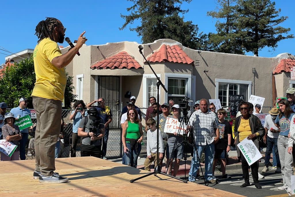 Seneca Scott speaking to a crowd of people at an outdoor event. Seneca Scott