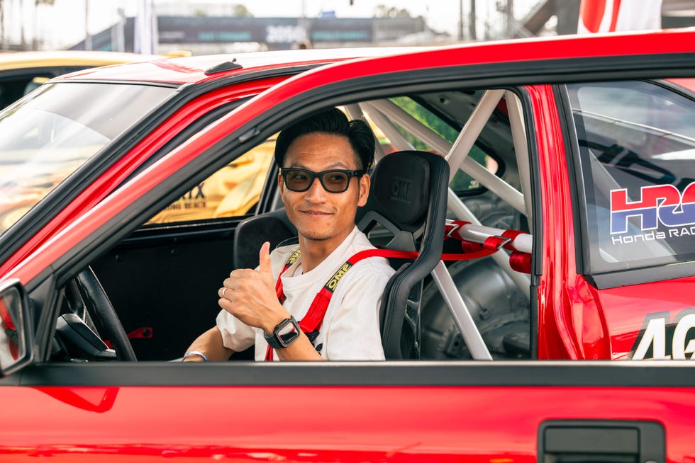 driver in a racing car giving a thumbs up
