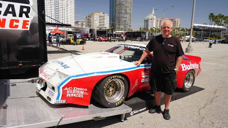 race car displayed at an event with a person standing next to it