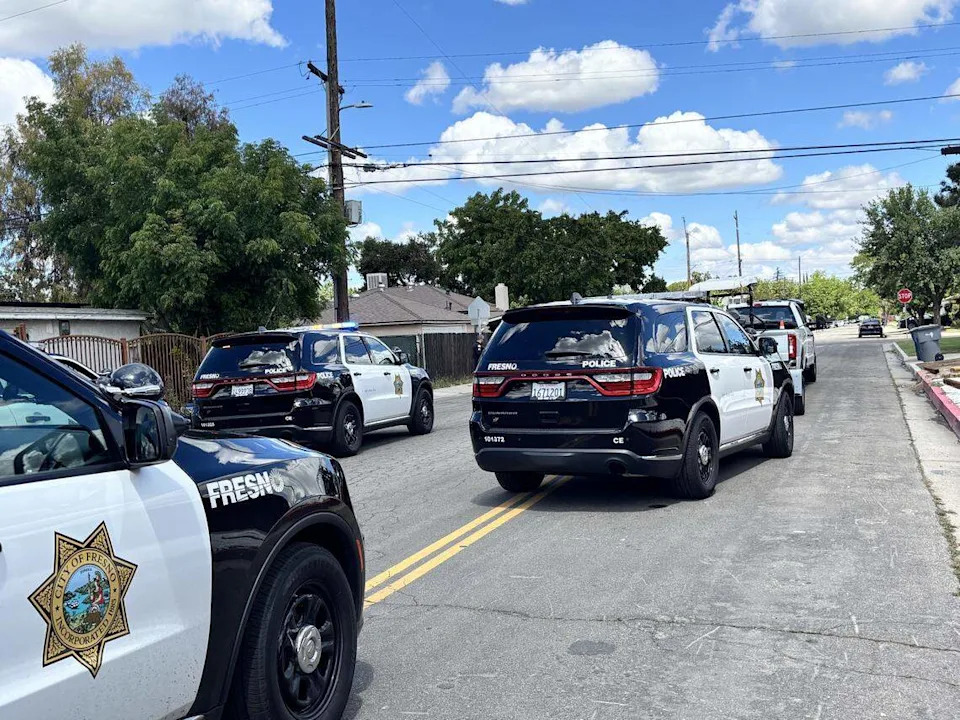 Fresno police vehicles line the road near Harrison and Shields avenues in Fresno, where good Samaritans helped rescue two kidnapped children.
