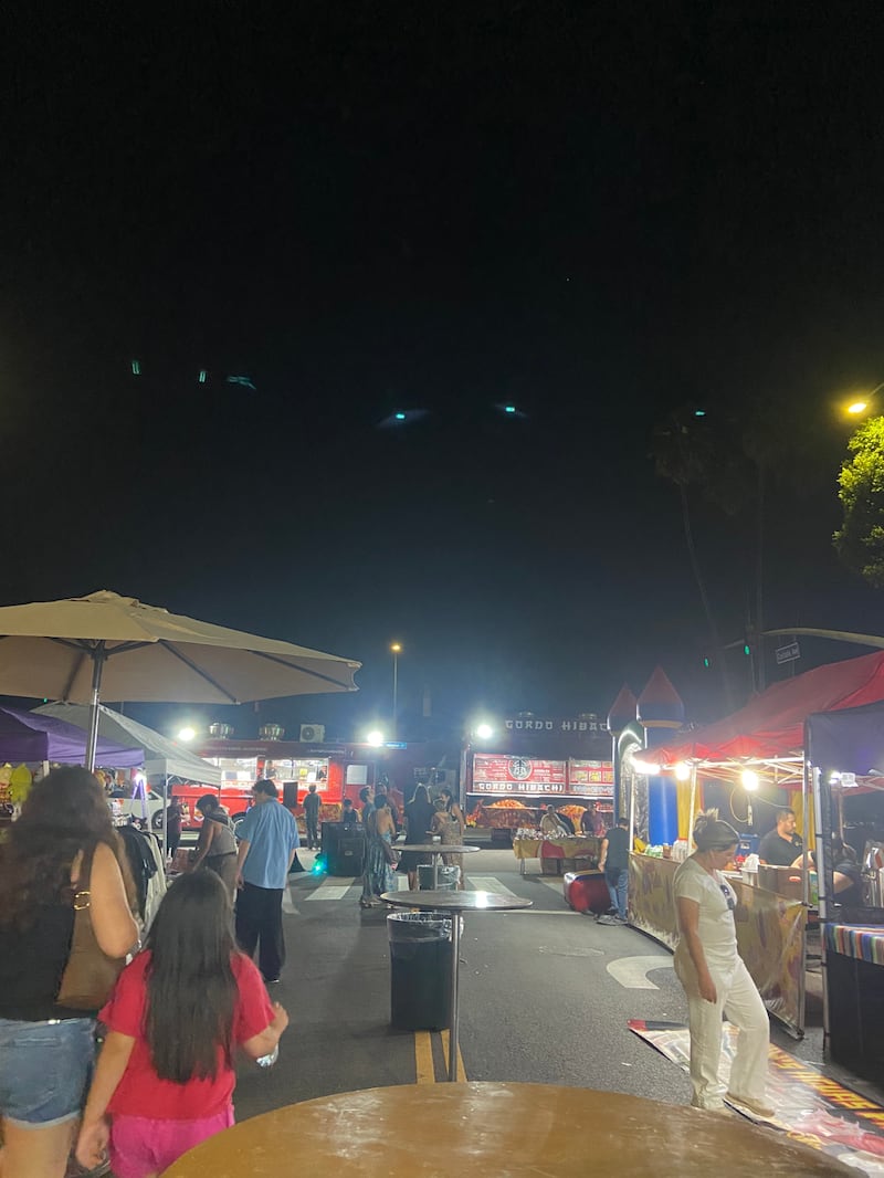 Photo of people walking around at a night market.
