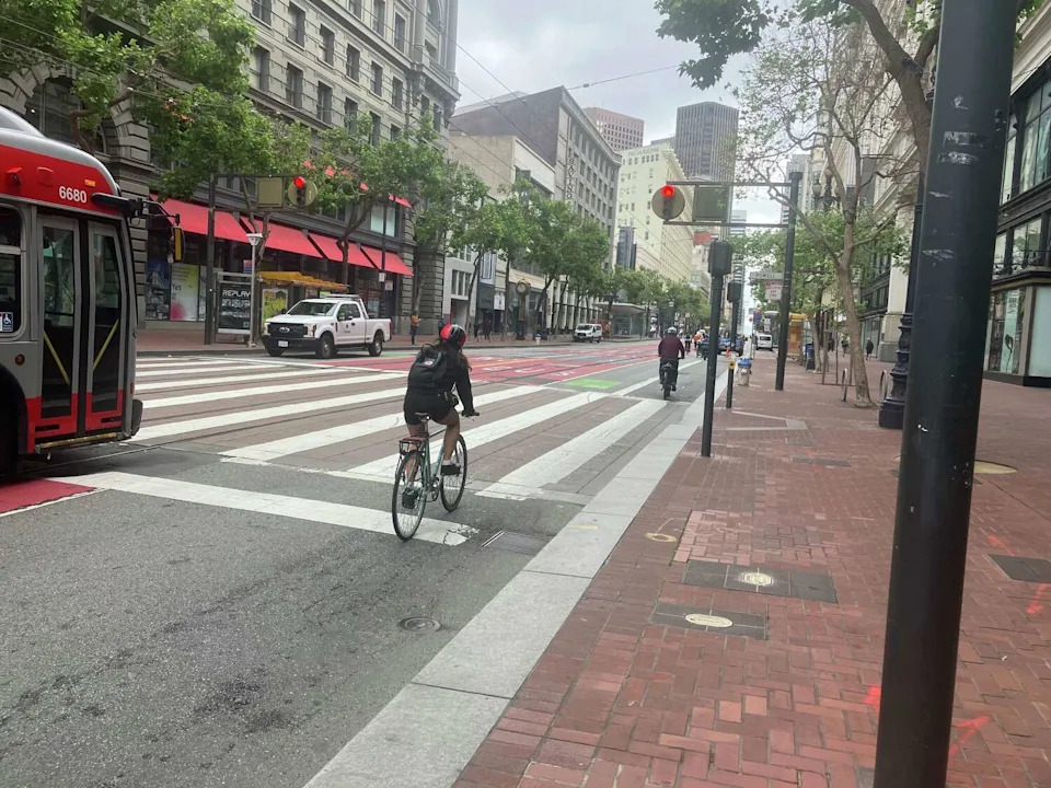 Bicyclists run a red light at Powell and Market in San Francisco monday morning. The city is cracking down on bicyclists who break rules. (Rachel Swan / S.F. Chronicle)